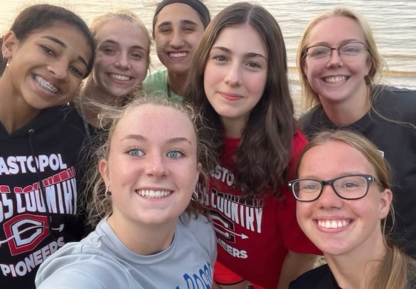 Stanger (in red) poses with the cross country team after practice.