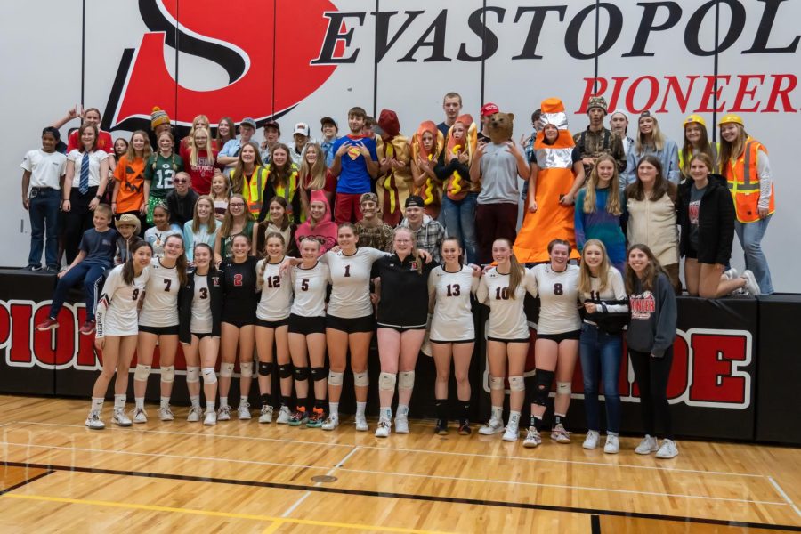 The fan section poses with the volleyball team after their win over Marion in four sets on Thursday, Oct. 20.